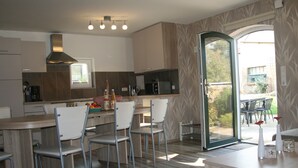 A modern kitchen with a central island, white chairs, and a dining table. - Elegant Mansion in Bastorf near Sea (Bastorf)