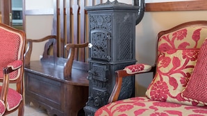 A room with a wooden table, a chair, and a decorative stove. - Vila Flor Pool Retreat (Vila Flor)