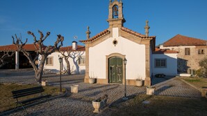 A small white church with a bell tower, cobblestone pavement, and a bench. - Vila Flor Pool Retreat (Vila Flor)