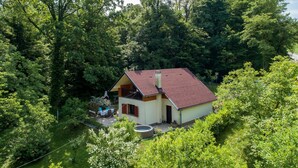 A two-story house with a red roof, surrounded by dense greenery. - Lovely Holiday House With Big, Private Garden, Near Well Known SPA Centre (Tuhelj)