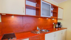 Une cuisine avec des meubles en bois, un évier en acier inoxydable et une machine à café.