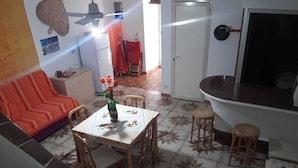 Een eetgedeelte met een tafel, stoelen en een bloevas.
