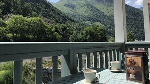 A balcony with a view of green hills and a house in the distance. - T2 +alcove, récent 4/5 pers. Parking. Balcon. Wifi (Cauterets)