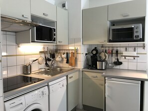 Moderni keittiö, jossa on Bosch-astianpesukone, mikroaaltouuni ja kahvinkeitin.