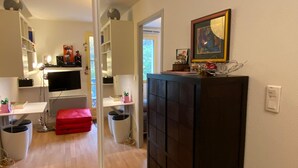 A modern living room with a flat-screen TV, a black cabinet, and a red ottoman. - T2 alcove confortable pour 4 à 5p. Balcon. Parking (Cauterets)
