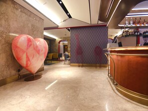 A modern bar area with a marble floor, a large heart-shaped decoration, and a bar counter with bottles. - Manxin Temple of Heaven North Gate Qiaowan Metro (Beijing)