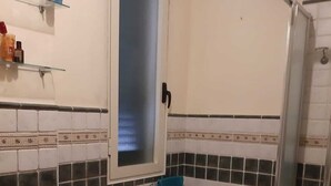 A bathroom with white and black tiled walls, a sink, a toilet, a shower, and a small wicker basket. - Casa Brezza (Scicli)