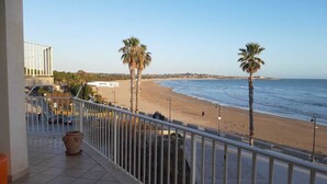 A balcony with a view of a beach, palm trees, and a clear sky. - Casa Brezza (Scicli)