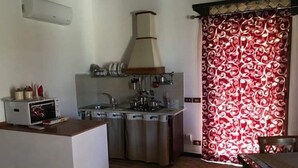Una cucina compatta con forno a microonde, lavello e fornello.