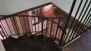 Una scala a chiocciola con ringhiera in metallo nero che conduce a un livello inferiore.