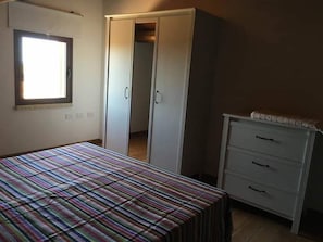 A bedroom with a bed, a wardrobe, and a window. - Casale Oasi (Pozzallo)