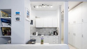 A compact, modern room with a kitchenette, a bed, and a wardrobe. - Beautiful studio at Panathenaic Stadium (Athens)