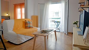 Una habitación con un sofá blanco, una mesa de madera y vistas a un balcón con barandilla.