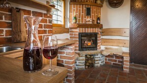 Un interior rústico con chimenea de ladrillo, estantes de madera y un banco de madera.
