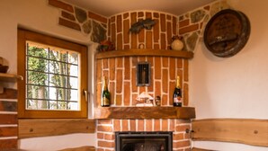 Una acogedora chimenea con detalles de piedra, una ventana con vista a árboles y un rústico banco de madera.