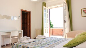 A bedroom with a bed, a desk, and an open door leading to a balcony. - The Villa of Lemons - Panoramic Villa with pool (Formia)