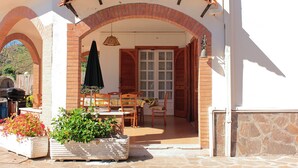 A covered patio with a brick archway, a wooden table and chairs, a hanging umbrella, and potted plants. - The Villa of Lemons - Panoramic Villa with pool (Formia)