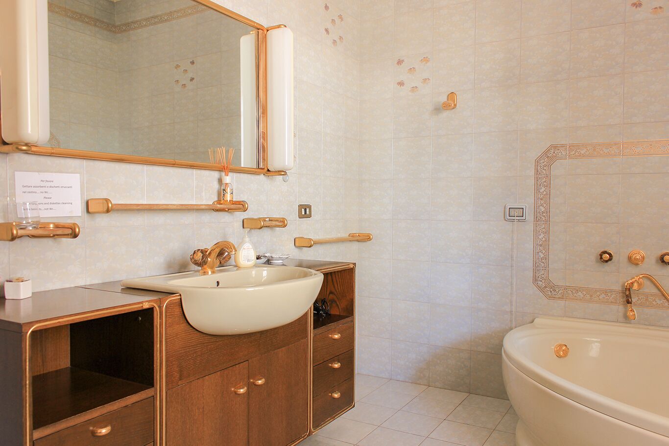 Un baño con un espejo grande, tocador de madera y una bañera.