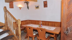 Ein Holztisch mit einer Bank, eine Holztreppe und eine Wandleuchte.