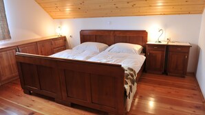 Ein Schlafzimmer mit einem hölzernen Bett, einem Nachttisch und einer Kommode.