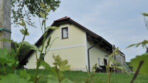 Ein eingeschossiges Gebäude mit einem geneigten Dach, einem kleinen Fenster und einer Tür.