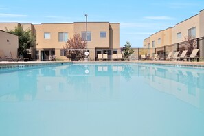 A swimming pool with lounge chairs and a building in the background. - Pet Friendly | Same Day Bookings | Townies | Poolside |  EPA Cleaning 432 (Moab)