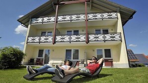 Un bâtiment à deux étages doté d’un balcon et d’un panneau solaire sur le toit.
