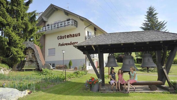 Un bâtiment portant l’inscription « Castehaus », avec un clocher et une statue au premier plan.