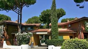 A building with a tiled roof, surrounded by greenery and trees.
