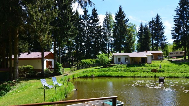 En fastighet vid sjön med en brygga, en liten båt och en rad hus.