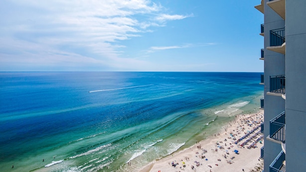 A beach with clear blue water and a building with balconies overlooking the beach. - Amazing Gulf Front Unit for 8!beach srvc included!!! (Panama City Beach)