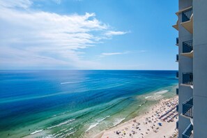 A beach with clear blue water and a building with balconies overlooking the beach. - Amazing Gulf Front Unit for 8!beach srvc included!!! (Panama City Beach)