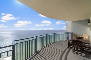 A balcony with a view of the sea, a table with chairs, and a railing. - Amazing Gulf Front Unit for 8!beach srvc included!!! (Panama City Beach)