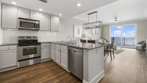 A modern kitchen with stainless steel appliances, a central island, and a view to the outside. - Amazing Gulf Front Unit for 8!beach srvc included!!! (Panama City Beach)