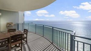 A balcony with a view of the ocean, a grill, and a table with chairs. - Amazing Gulf Front Unit for 8!beach srvc included!!! (Panama City Beach)