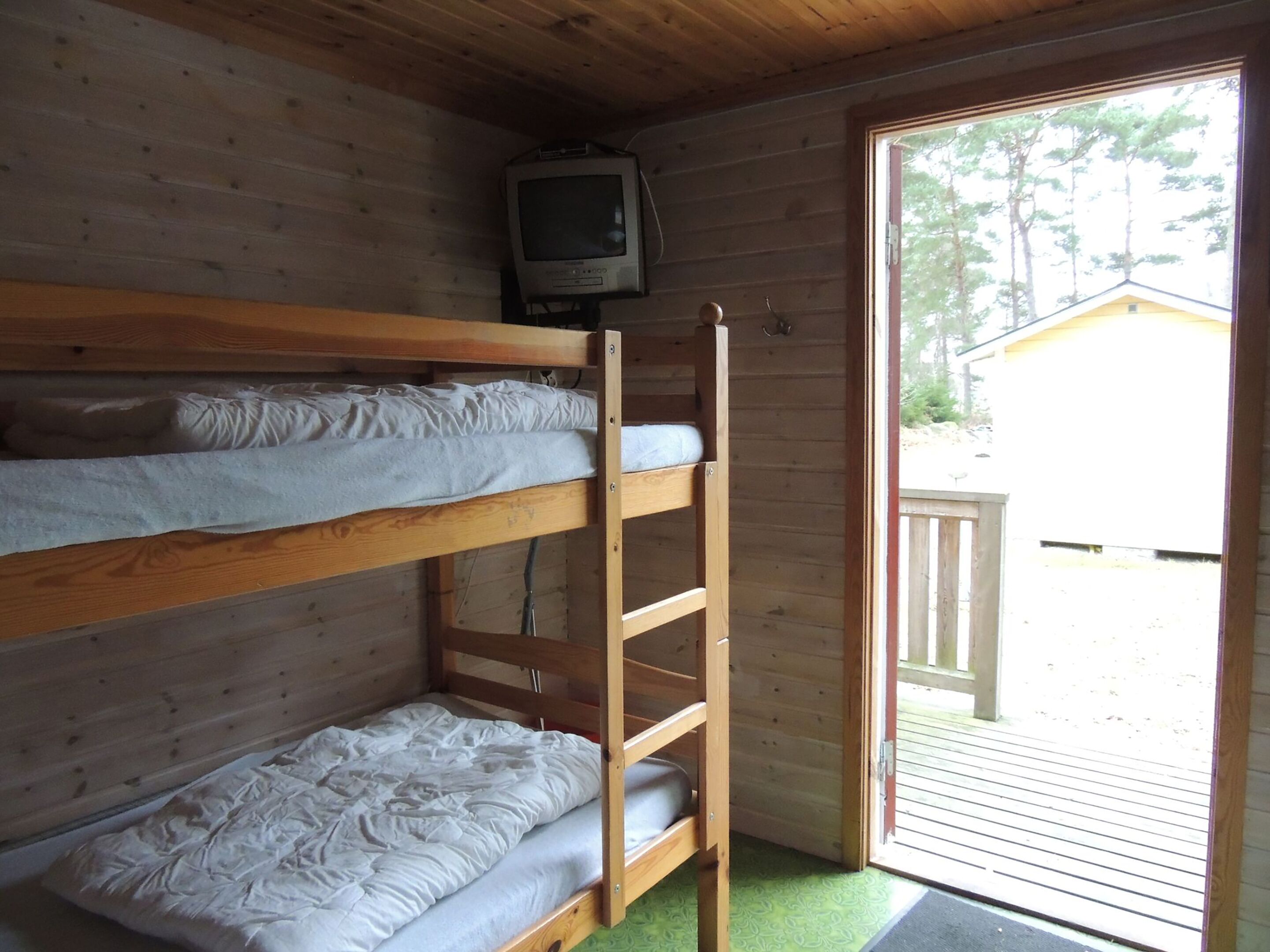 Habitación con literas y un televisor encima.