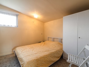 A small, single-bed room with a plain wall, a window with a white blind, and a white wardrobe. - Splendid Chalet in Gouvy With Fenced Garden (Gouvy)