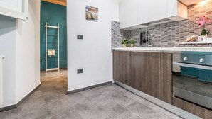 A modern kitchen with a wooden ceiling, a built-in oven, and a tiled backsplash.