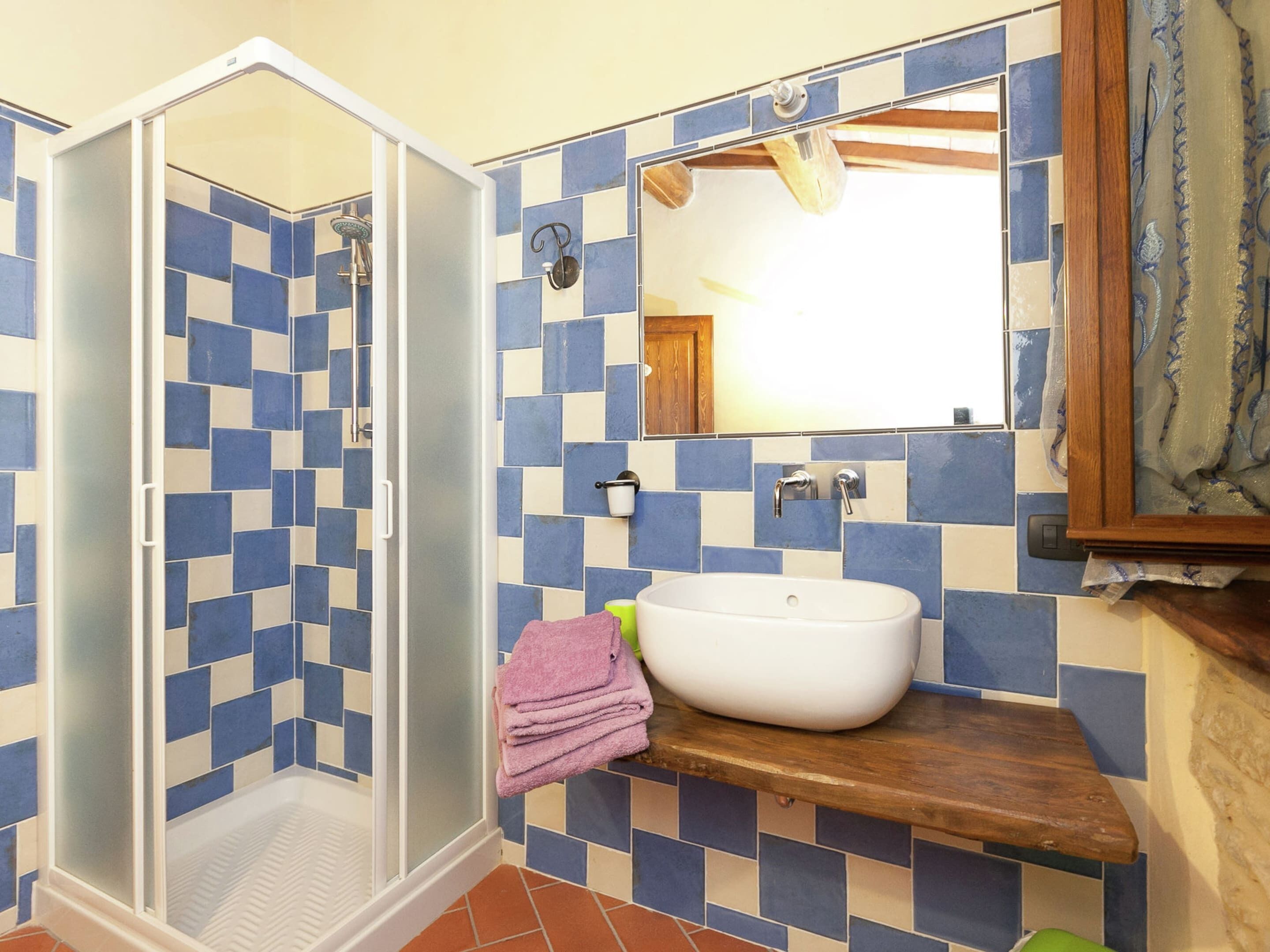 A bathroom with a shower, a sink, and a mirror.