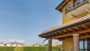 Une maison à deux étages dotée d’un patio couvert, d’une piscine et d’une pelouse bien entretenue.
