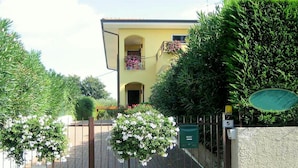A yellow building with a gated entrance, a mailbox, and a number '5' sign. - Holiday Home in Lazise Near Gardaland (Lazise)