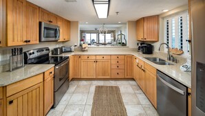 Una cocina moderna con armarios de madera, electrodomésticos de acero inoxidable y una isla grande.