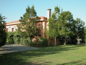 Set amidst a serene lawn and trees, this charming two-story building offers a peaceful retreat.
