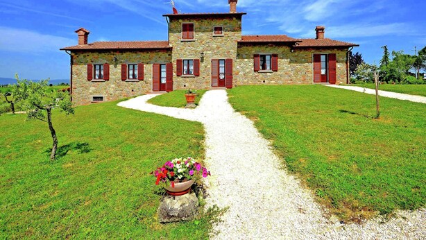 A stone house with a gravel driveway and a flower pot in the foreground. - Holiday Home in Tuscany With Pool & Vineyards (Cortona)