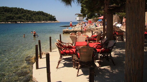 A beachside cafe with outdoor seating and a view of the sea. - Luxury Apartment With Private Balcony in Quiet Area (Dubrovnik)
