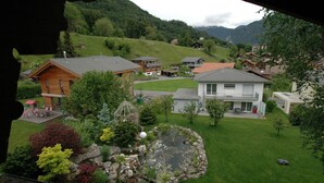 A residential area with houses, a garden with a pond, and a mountainous backdrop. - Pristine Home in a Charming Village, Large Grassy Sunbathing Area, View of the Mönch and Jungfrau (Wilderswil)