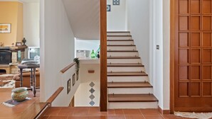 A staircase leading to a second floor with a wooden door on the right. - Belvilla by OYO Quaint Villa in Carini With Garden (Carini)