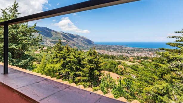 A balcony with a metal railing overlooking a coastal cityscape with mountains in the background. - Belvilla by OYO Quaint Villa in Carini With Garden (Carini)