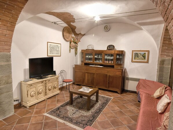 A living room with a television, a cabinet, a chair, and a sofa. - Belvilla by OYO Villa Paola (Cortona)