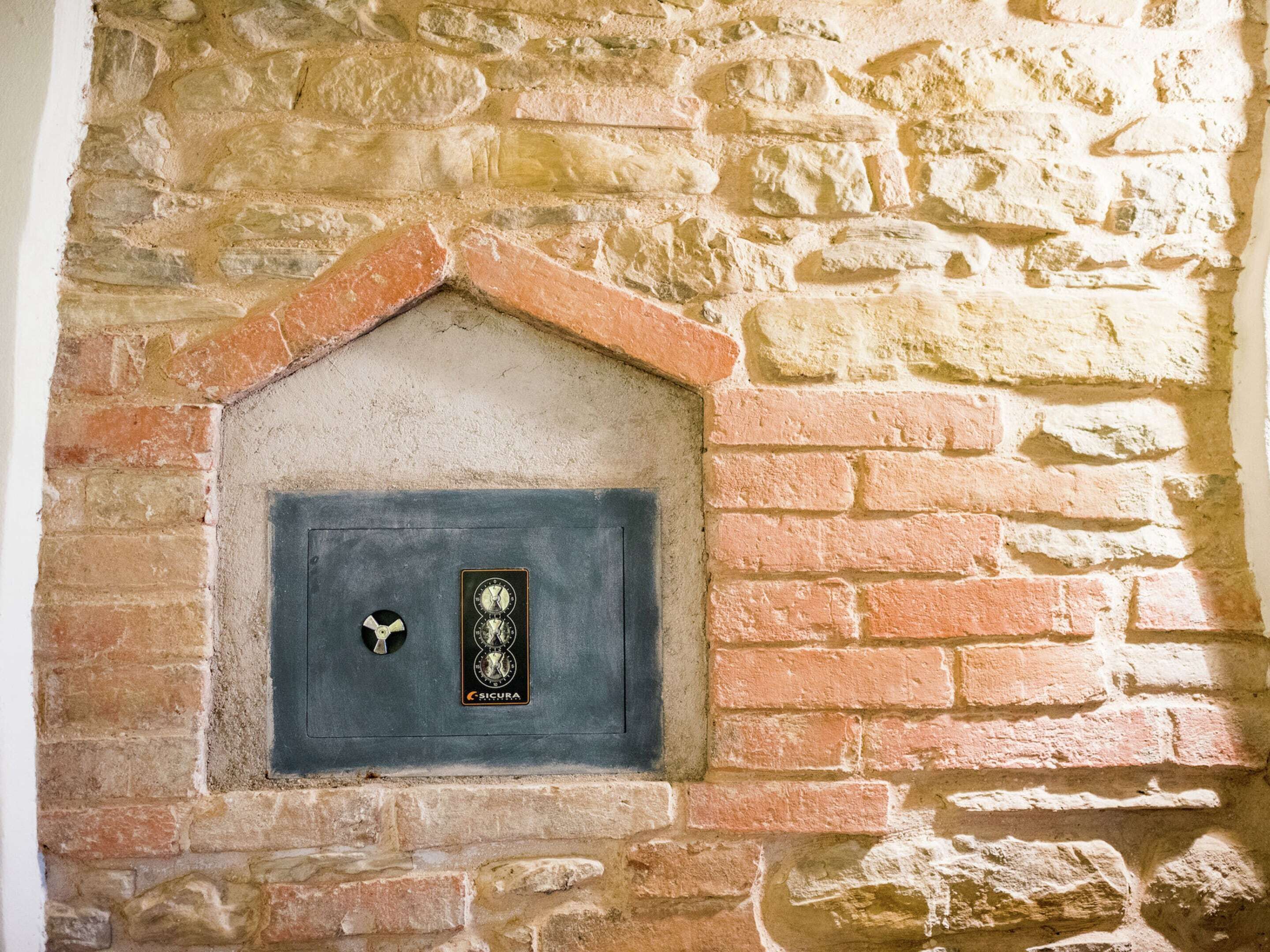 A stone wall with a brick fireplace.